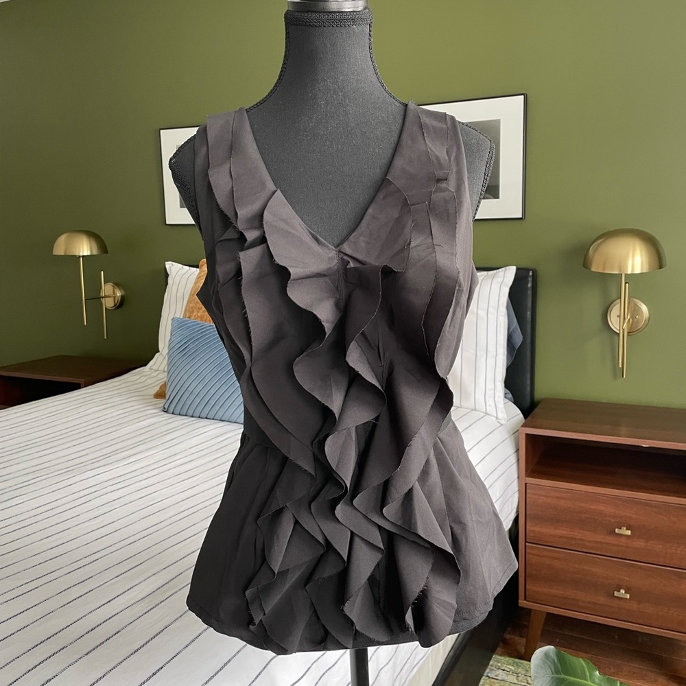 Black blouse with front frill and elastic waist. Size L.